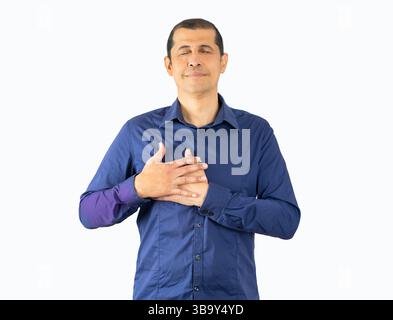 Middle age hoary man wearing casual blue shirt over isolated white background smiling with hands on chest with closed eyes and grateful gesture on fac Stock Photo