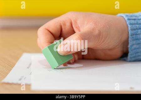 Close up of woman hand using rubber erasing pencil drawing on a desk at home Stock Photo