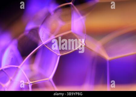 Green, orange and purple liquid reflections on dark background, bright liquid surface Stock Photo