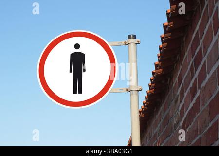No pedestrian traffic sign. Red circle with walking ban symbol. Road safety warning. Traffic restriction for walkers. Urban street sign on pole. Stock Photo