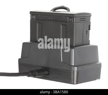 Riflescope's power source that has been taken outof the night vision optic and in the cradle for recharding isolated on a white background. Stock Photo