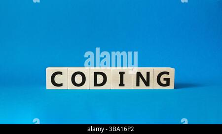 Coding symbol. Concept word Coding on wooden cubes. Beautiful blue background. Business and Coding concept. Copy space. Stock Photo