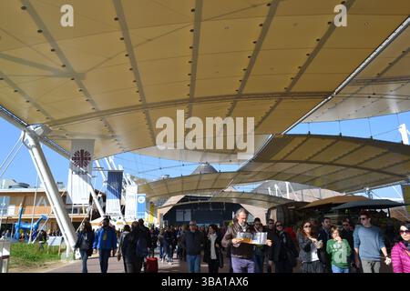 EXPO Milano 2015. View of the big tops of Decumano Street. Enormous crowd of people passing along the avenue looking for expo curiosities. Sunny day. Stock Photo