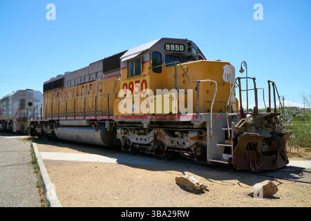 Barstow, California, USA. 7th May, 2025. Photographed at the Western America Railroad Museum in Barstow, Union Pacific 9950 sits in quiet retirement, its once-bright Armour Yellow paint now sun-bleached and streaked with rust. This diesel-electric locomotive served for decades in Union Pacific's freight fleet, pulling heavy loads across the American West.Now out of service and on static display, 9950 still carries the weight of its working past. Its weathered surface and sturdy form tell a story of power, utility, and the long-haul muscle that kept the railroads moving. A monument to enduran Stock Photo