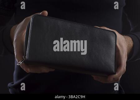 Black purse in male hands Stock Photo