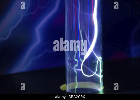 A purple and blue glowing tube with a red line running through it. The tube is lit up and he is a neon light Stock Photo