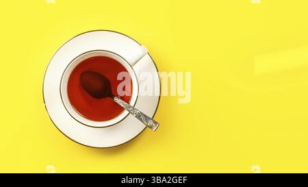 Flat lay photo, white porcelain cup of hot tea with silver spoon, on yellow board, space for text right, Liptovsky Hradok, Slovakia, Europe Stock Photo