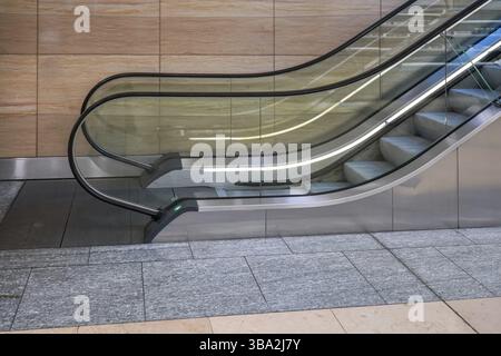 Escalator in modern building, side view with marble wall in background, London, United Kingdom, Europe Stock Photo