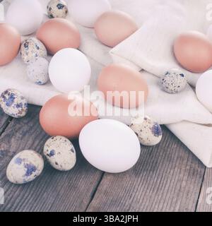 Eggs on textile tablecloth over rustic wooden table Stock Photo