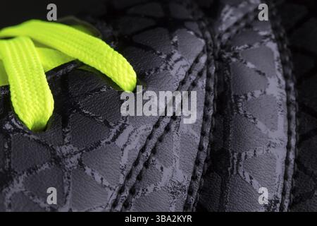 Fragment of black sneaker with green laces close up. Sneaker texture Stock Photo