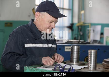 Belarus, the city of Gomil. April 18, 2022. Turning production An elderly man works at a lathe. Turning works, Europe Stock Photo