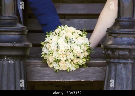 Wedding bouquet in the hands of the groom and the bride Stock Photo