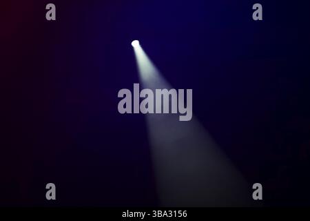 White smoky beam of stage light on a dark background Stock Photo