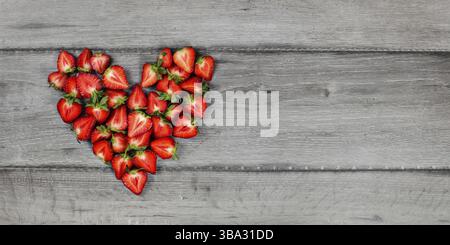 Top-down view - heart made of strawberry pieces on gray wood desk. Space for text on right, Liptovsky Hradok, Slovakia, Europe Stock Photo