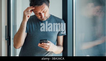 Reading worrying text message on mobile phone, selective focus Stock Photo