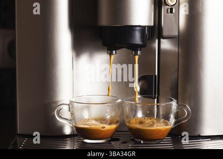 Coffee machine brewing a coffee espresso in home, two glass cups Stock Photo