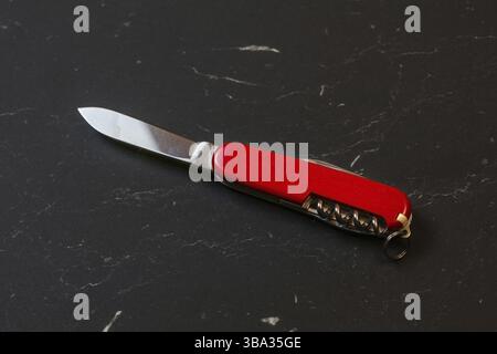 Red pocket knife on black table, Liptovsky Hradok, Slovakia, Europe Stock Photo