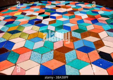 Colorful ceramic rhombus tiles creating a vibrant geometric pattern, forming an intriguing optical illusion that captivates the eye Stock Photo