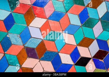 Colorful ceramic rhombus tiles creating a vibrant geometric pattern, forming an intriguing optical illusion that captivates the eye Stock Photo