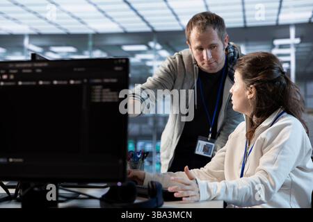 IT engineers in server farm brainstorming ways to repair equipment storing datasets. Colleagues at work in data center discussing how to mend rigs doing computational operations Stock Photo