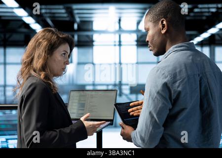 Engineers in data center using devices, employing machine learning models, analyzing historical usage patterns, predicting future infrastructure needs, allocating resources efficiently Stock Photo
