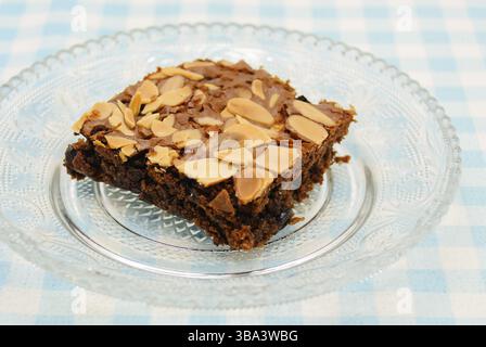 Chocolate brownie with almond topping on glass plated Stock Photo