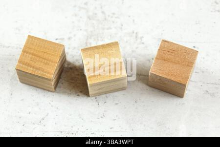 Three empty wood playing cube blocks on white board, Liptovsky Hradok, Slovakia, Europe Stock Photo