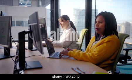 Programmers working on computers in modern office Stock Photo