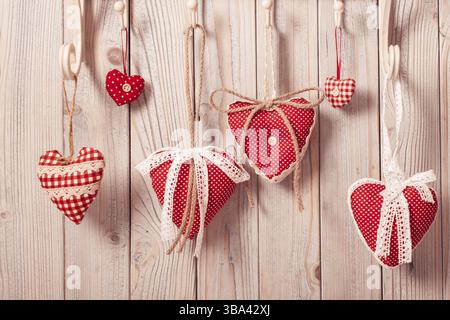 Red hearts hanging on the hooks.Christmas or Valentine greetings Stock Photo