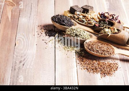 Various of dried tea in wooden scoops and spoons with copy space Stock Photo
