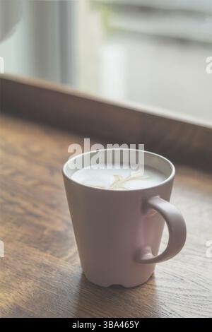Coffee cup in coffee shop, vintage style effect picture. Cup of coffee latte on wood bar Stock Photo