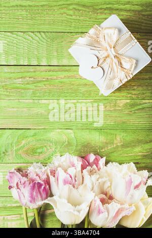 Pink tulips and gift box on a green wooden table Stock Photo