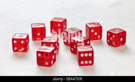 Ten red translucent craps dices on white board showing different numbers, Liptovsky Hradok, Slovakia, Europe Stock Photo