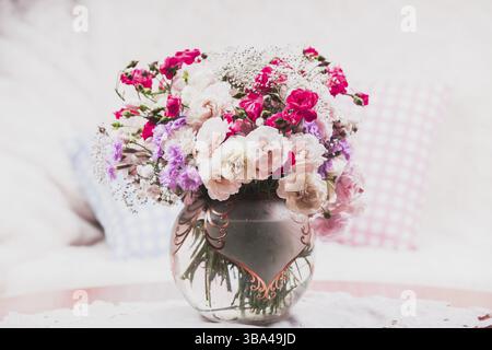 Flower bouquet on the table near the sofa with a pillow Stock Photo