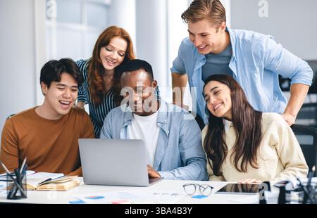 Group of international people using laptop and smiling Stock Photo