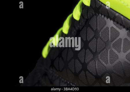 Fragment of black sneaker with green laces close up. Sneaker texture Stock Photo