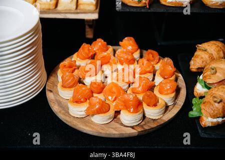 Elegant smoked salmon appetizers served on puff pastry shells, ideal for upscale events, catering, and gourmet finger food menus. Stock Photo