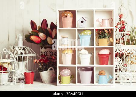 Colourful Eggs in miniature buckets and cans in shadowbox. Spring and Easter decor Stock Photo