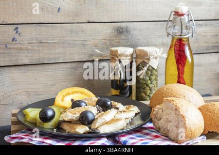 Fried mushroom eryngii with pickles, fresh tomatoes, black olives and sesame, bran bread on the rustic wooden lattice, black makisu and checkered napk Stock Photo