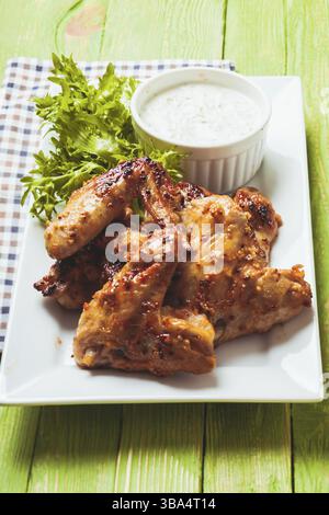 Roasted Chicken wings and tzatziki sauce on a plate Stock Photo