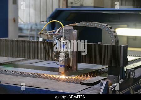 Cutting of metal. Sparks fly from laser.Laser cutting machine working with sheet metal with sparks at factory, plant Stock Photo