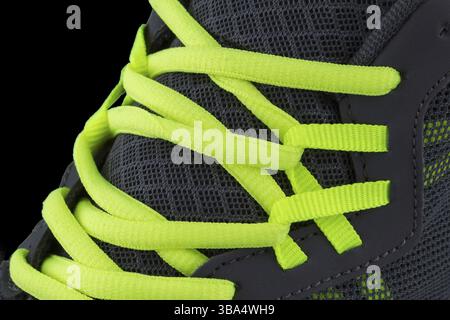 Fragment of black sneaker with green laces close up. Sneaker texture Stock Photo