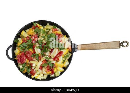 Frying pan with vegetables on a white background. Fried tomatoes, zucchini and herbs Stock Photo