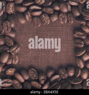Spilled coffee beans frame over linen textile Stock Photo