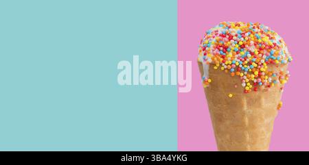 Ice cream in a waffle cup close-up with multicolored dressing. Sweet dessert on pink blue background banner Stock Photo