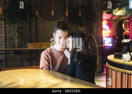Theme love and holiday Valentines Day. couple of college students together in Caucasian heterosexual lovers winter inside the cafe sit at empty table Stock Photo