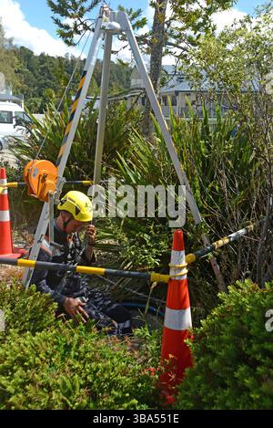 An apprentice plumber enters a confined space for a training exercise in a storm water drain on a commercial property Stock Photo