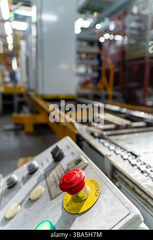 Emergency Stop installed at line conveyor in refrigerator manufacturing plant. START - STOP button for industrial machine. Industrial and factory conc Stock Photo