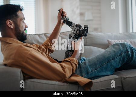 Handsome engineer student working on robot project at home. Stock Photo