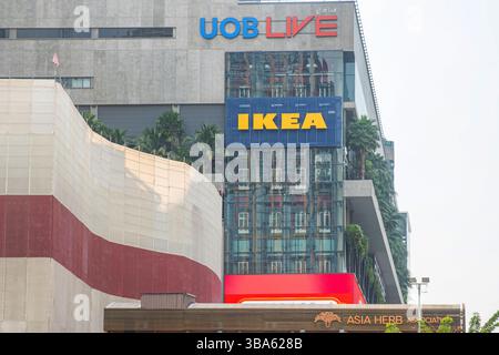 Bangkok, Thailand - February 20, 2025: IKEA store sign on Emsphere shopping mall modern glass building with palm trees and surrounding retail signage Stock Photo